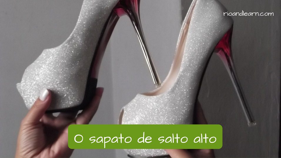 Diferentes tipos de calzados en portugués. O Sapato de salto alto: El zapato de tacones. También podemos llamar a este de sapato agulha por ser muy fino. En la imagen aparece un par de zapatos con un tacón bien alto y fino de color plateado con su descripción en portugués.